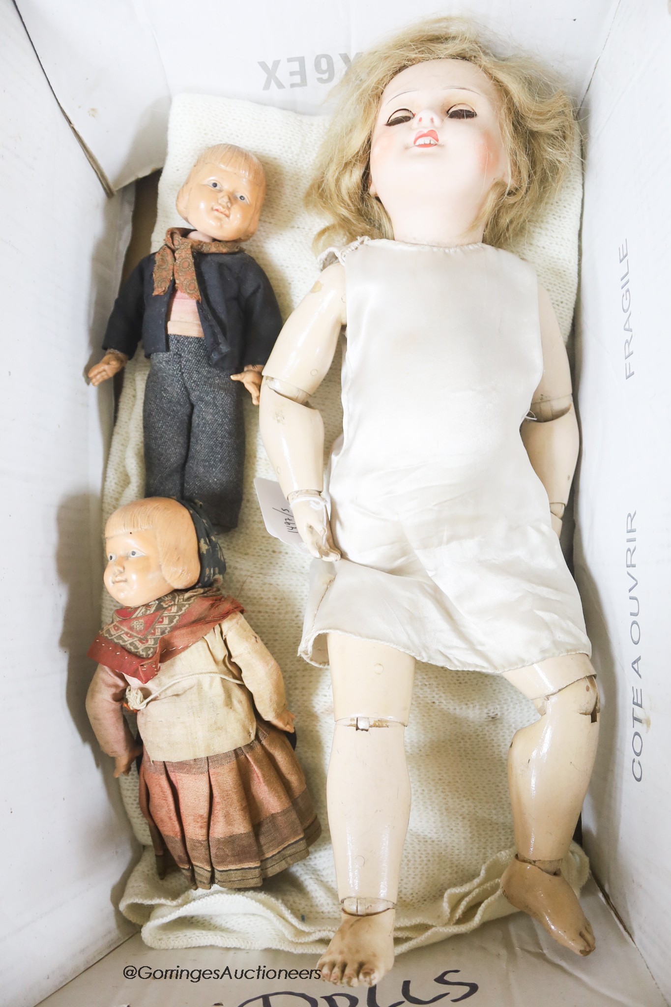 A bisque headed doll, believed by family repute to have been Princess Beatrice's and two celluloid dolls